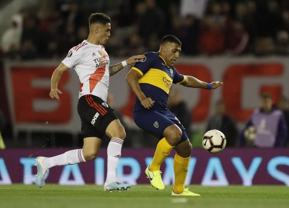 LA REVANCHA. Martínez Quarta persigue a Ramón Ábila, durante el partido de ida. Ambos volverían ser titulares esta noche en La Bombonera, que rugirá para alentar a Boca.  