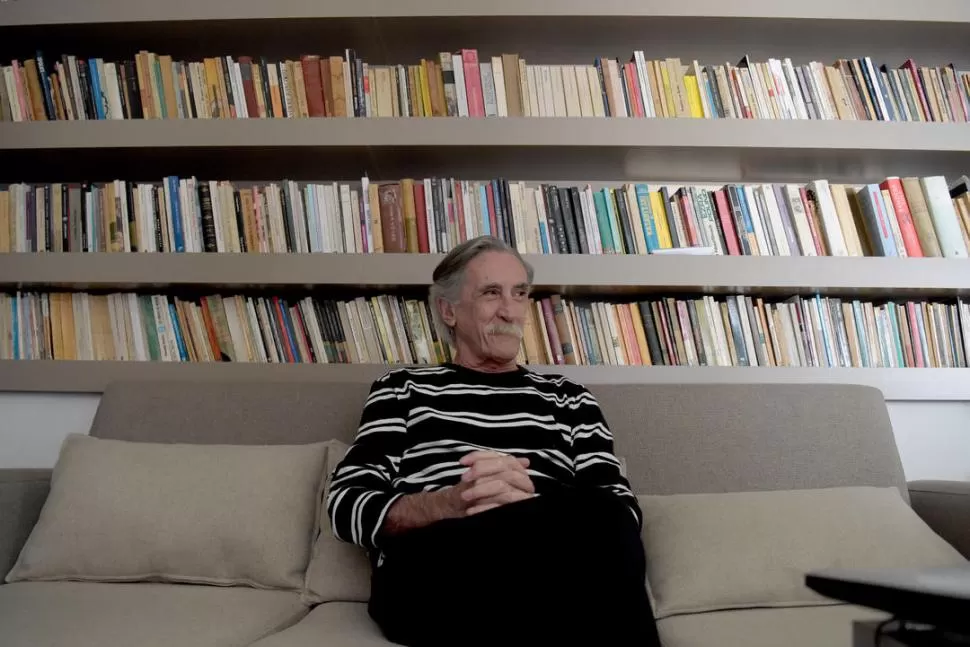 VÍCTOR REDONDO. El poeta en el living de su casa, delante de su biblioteca. 