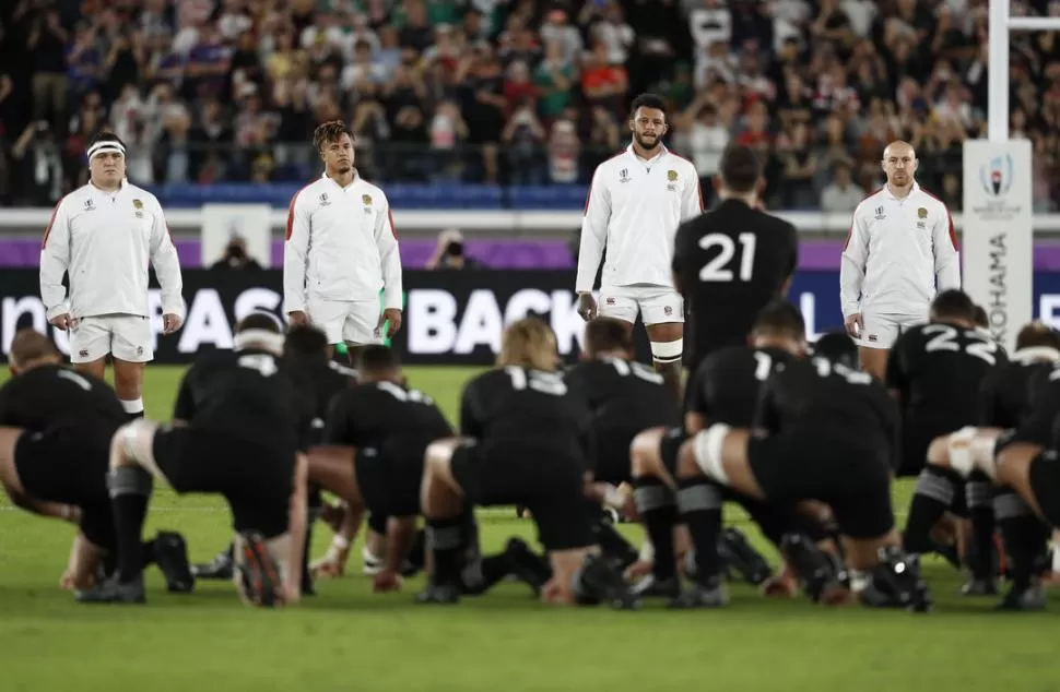 GRAN MOMENTO EN JAPÓN. Los jugadores neocelandeses hacen su mítico haka; los ingleses los desafían, mirándolos de frente y formando en forma de V. 