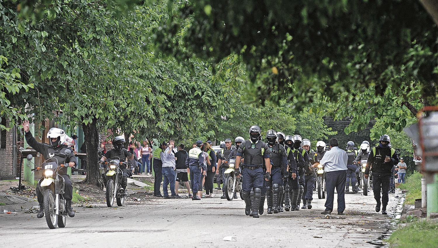 ESCENARIO. Los uniformados se desplazan en la zona del conflicto. Atrás, parientes y vecinos del joven asesinado. 