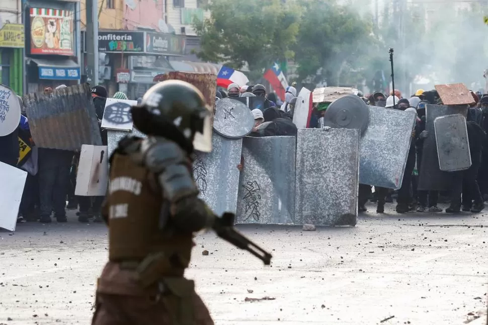 SIN CUARTEL. Los manifestantes se cubren del accionar de Carabineros. reuters