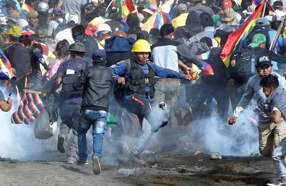 DISTURBIOS. Manifestantes que repudian el derrocamiento de Morales arrojan contra la Policía las granadas de gas lacrimógeno que las fuerzas les lanzaron para dispersar la protesta, durante los incidentes del viernes en Cochabamba. reuters