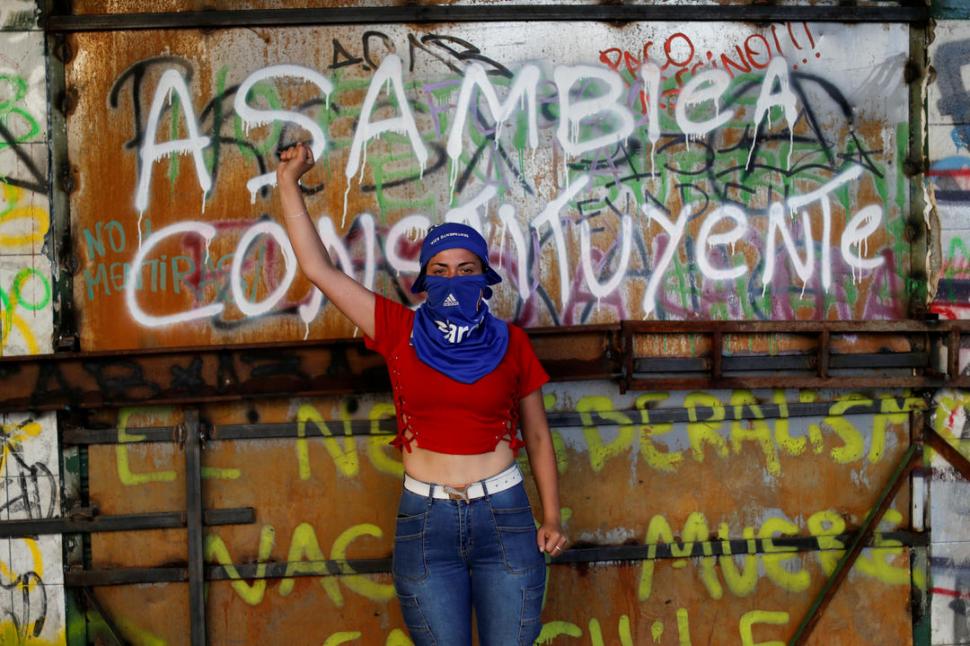 SENTIMIENTOS SUPERPUESTOS.  Esta pared  -se observa- permitió la catarsis una y otra vez. En el dolor y la bronca; también en la esperanza. Una joven chilena celebra el anuncio de que la  Constitución pinochetista por fin será modificada. 