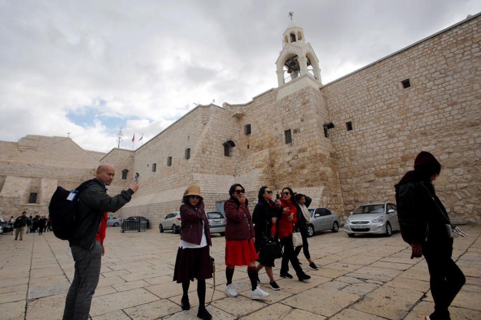  DE PASEO. Un grupo de turistas pasea por la Plaza del Pesebre, frente a la basílica de la Natividad.