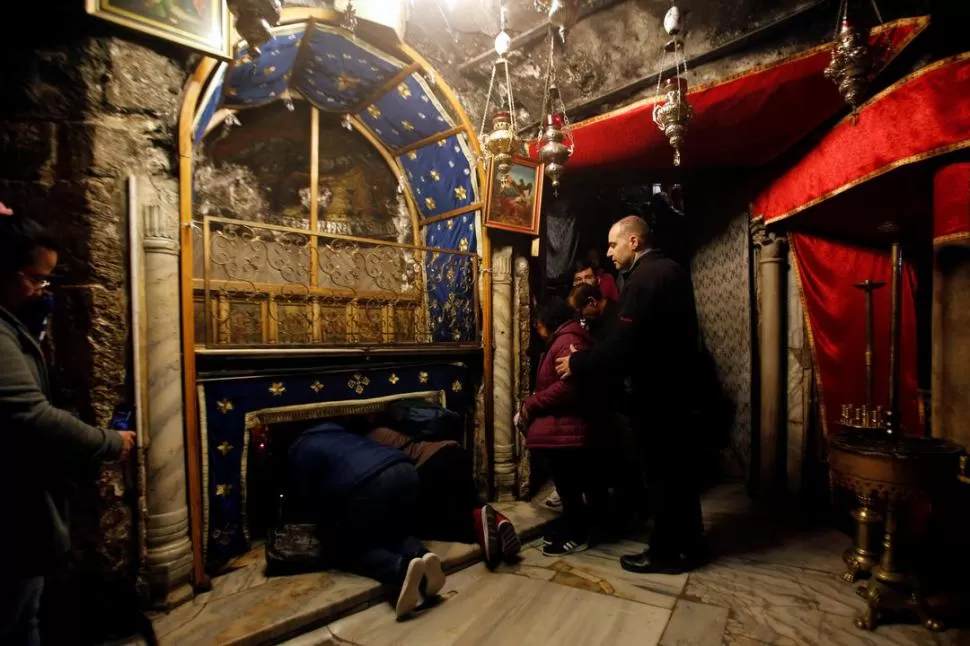 SELFIE. Turistas frente a la basílica de la Natividad. (Arriba, a la izquierda)PLEGARIAS. Fieles rezan ante la cueva donde, según la tradición, nació Jesús. (Arriba, a la derecha)ESPÍRITU NAVIDEÑO. Un turista se saca una foto junto a un palestino vestido como Papá Noel, en una calle de Belén. (Abajo, a la izquierda)DE PASEO. Un grupo de turistas pasea por la Plaza del Pesebre, frente a la basílica de la Natividad. (Abajo, a la derecha). fotos reuters