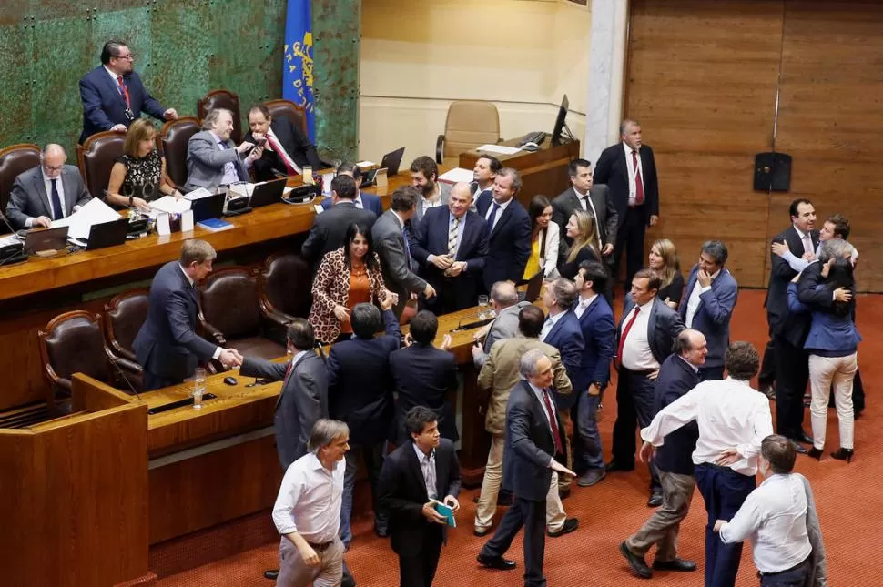 SALUDOS. Los legisladores que apoyan al Gobierno celebran la votación. reuters