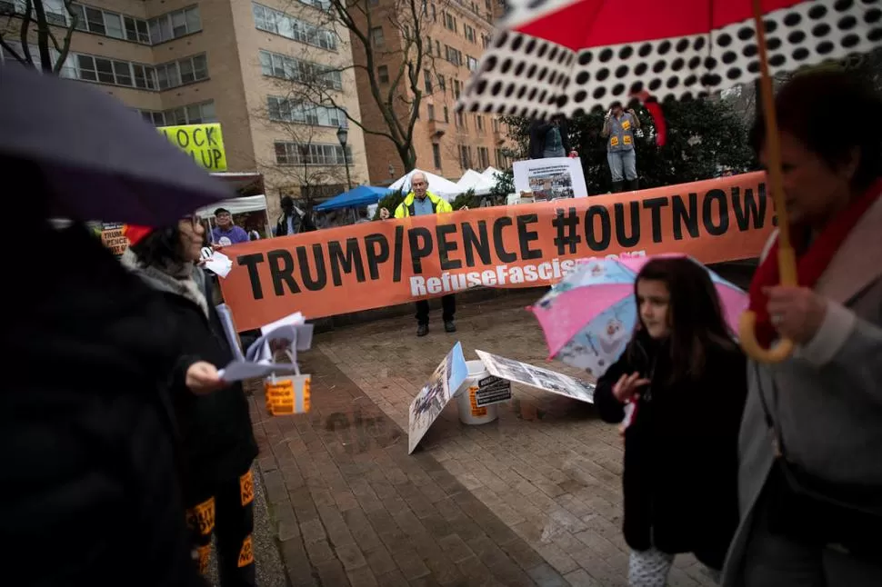REPUDIOS. Manifestantes marcharon frente campo deportivo donde estaba Trump, con carteles que piden su salida y el rechazo al “fascismo”.  reuters