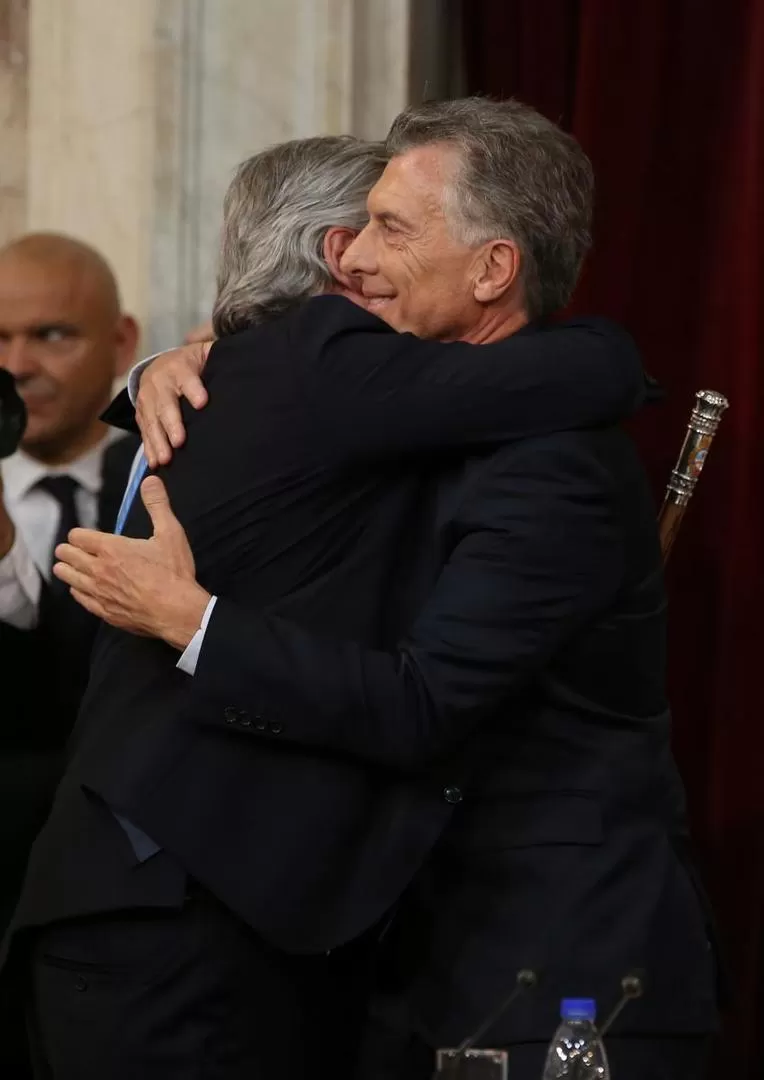 MEMORABLE. El Presidente saliente y el Presidente entrante se estrechan en un abrazo tras el cambio en el poder.