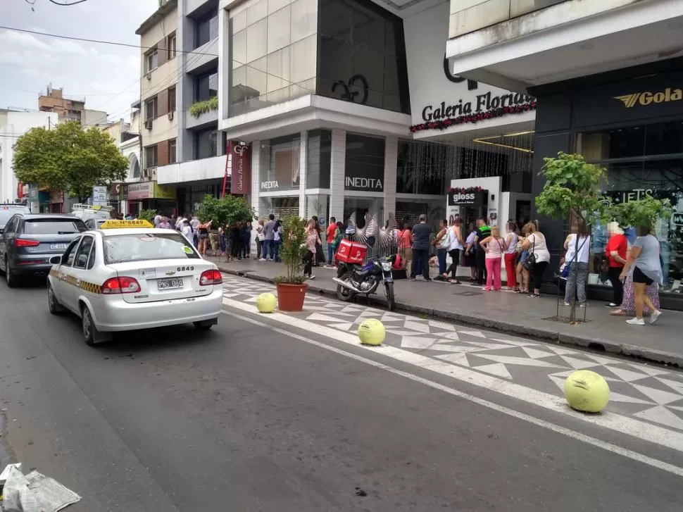 FILAS EN LA CITY TUCUMANA. Decenas de personas esperaron durante la siesta poder acceder a los U$S 200 que se permiten adquirir mensualmente. Quieren anticiparse a la vigencia del “impuesto país”.  