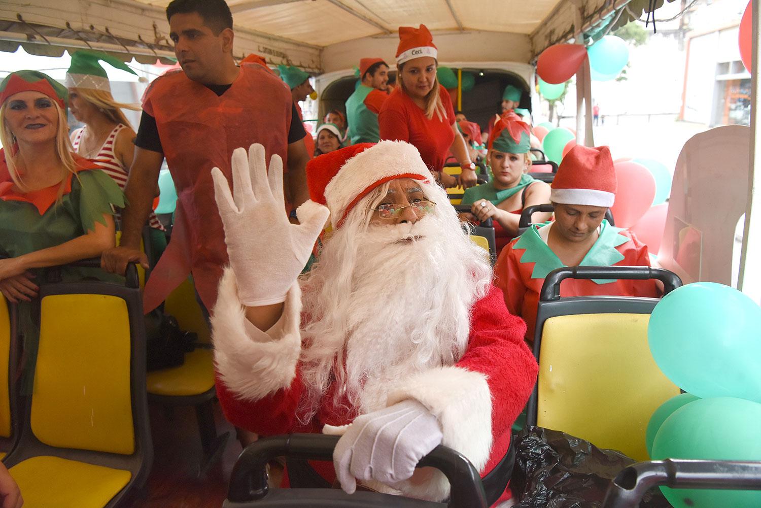 POSMODERNO. Papá Noel cambió el trineo con renos por un colectivo. Los duendes están felices por el espacio extra.