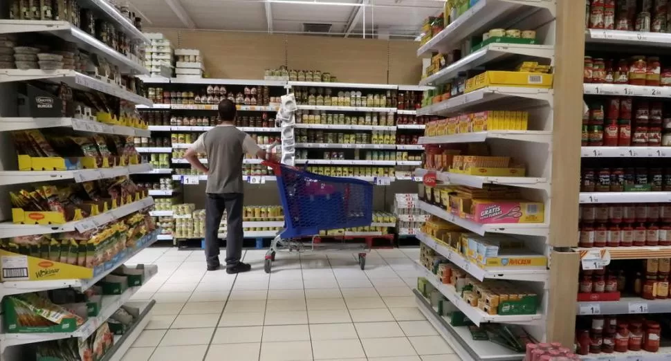 VENTAS MINORISTA. Una persona compara precios en un supermercado. Uno de los objetivos prioritarios del Gobierno nacional es potenciar las compras. REUTERS (archivo)