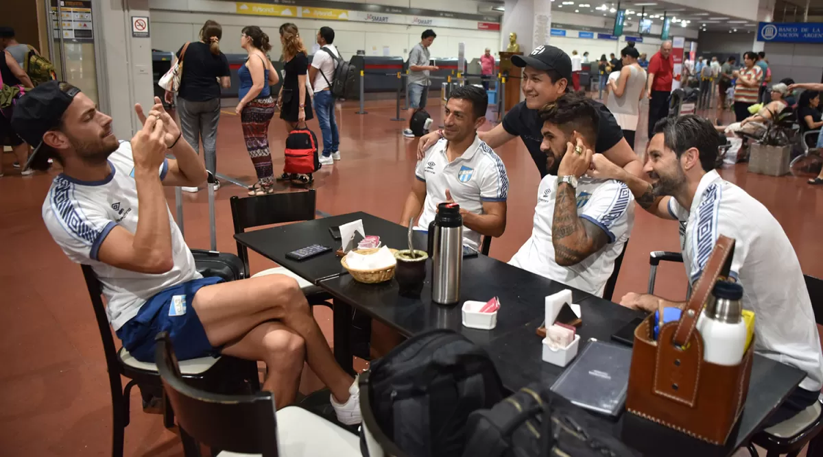 DISPUESTOS. Lucas Melano accedió a tomarle una fotografía a uno de los hinchas en el aeropuerto junto a Guillermo Acosta, Javier Toledo y Cristian Lucchetti.  LA GACETA/FOTO DE INÉS QUINTEROS ORIO