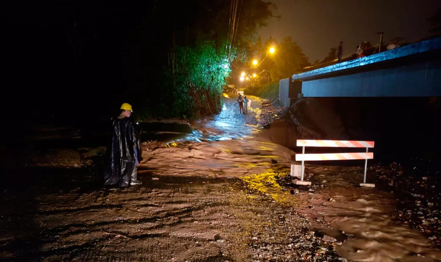 CUSTODIA. Un operario custodia la zona donde desapareció el terraplén ubicado en el río Muerto. FOTO ENVIADA A LG WHATSAPP