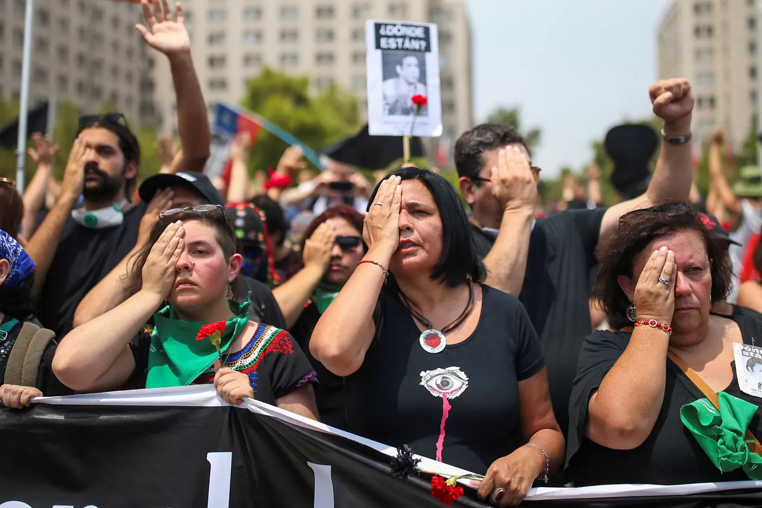 DENUNCIA. Chilenos marchan con una señal que alude a los manifestantes cegados por la represión de Carabineros.