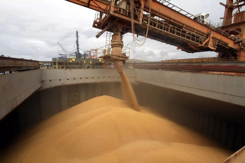 EN EL PUERTO. La bodega de un barco se llena de granos que serán exportados; en el sector esperan los efectos del acuerdo comercial. archivo 