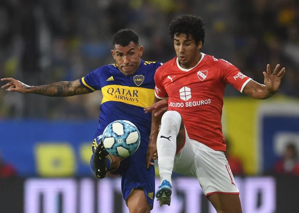 LUCHA. Carlos Tevez y Cecilio Domínguez disputan la pelota en La Bombonera. telam