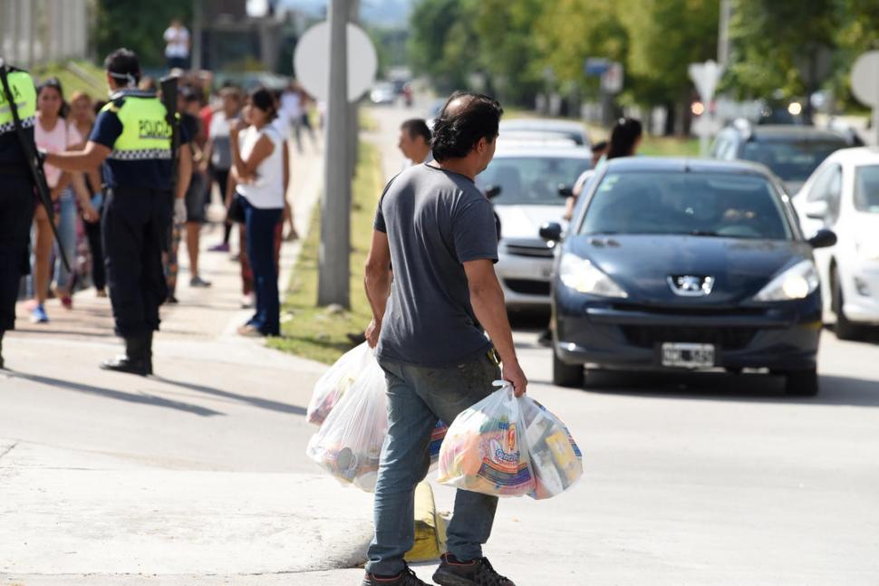 CARGADO. Un hombre sale del súper después de abastecerse.  