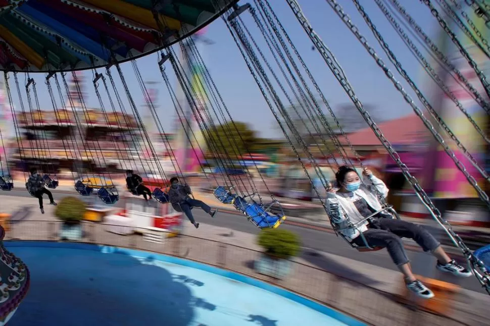 ALEGRÍA. Con máscaras, cientos de niños volvieron al parque Happy Valley, en Shangai, en el dia de reapertura. Reuters