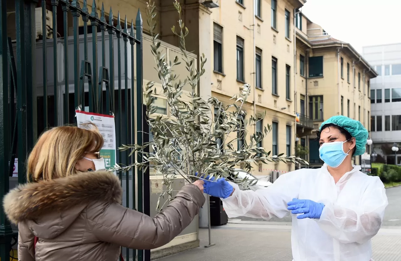 EN TURÍN. Una mujer le entrega un ramo a una enfermera. REUTERS 