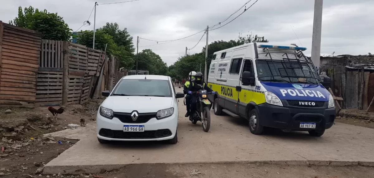 CON CUSTODIA. Los uniformados tuvieron que ingresar al barrio para que sus compañeros de Homicidios y los peritos terminaran de realizar los trabajos en el lugar donde se produjo el crimen del adolescente.