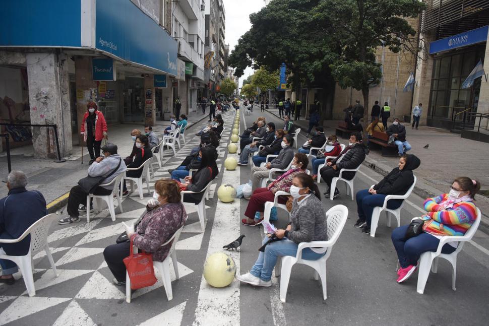 LA CALLE SE CONVIRTIÓ EN SALA DE ESPERA. Ayer, por orden de la Justicia, se comenzó a ordenar las largas colas que se formaban en los centros de pagos. Por ese motivo se colocaron sillas en las calles del microcentro. la gaceta / fotos de analia jaramillo - juan pablo sánchez noli -  diego aráoz 