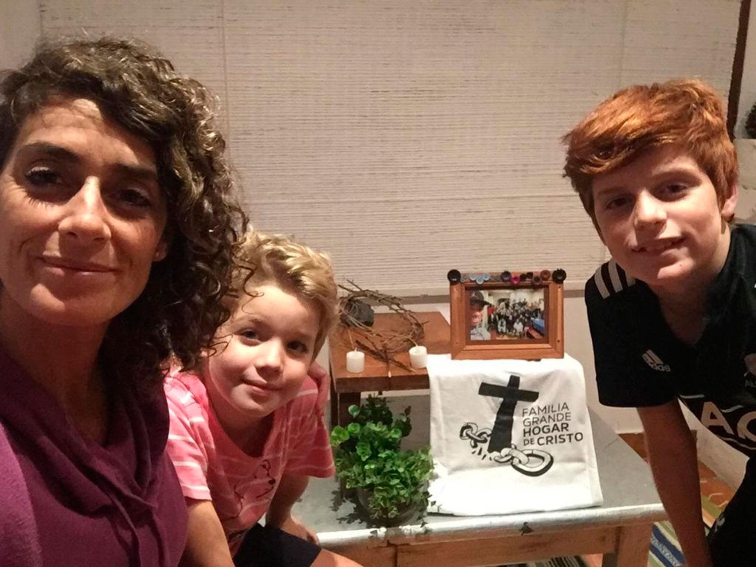 ROMINA RODA. Junto a sus hijos, Martín y Julián, con el altar familiar en su casa.