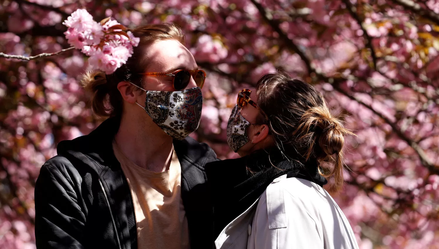 LA PRIMAVERA. Dos jóvenes con tapa bocas aprovechan el día de sol en Berlín.