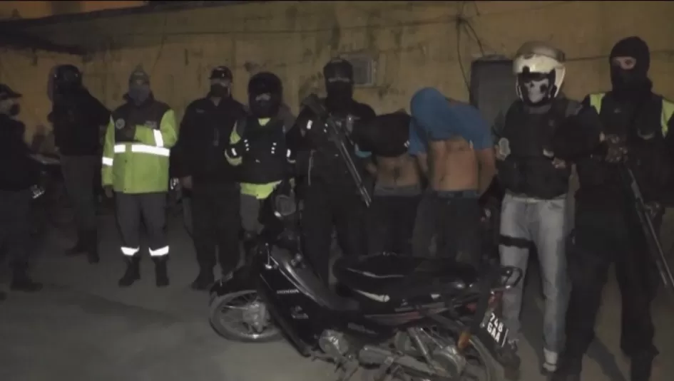 ARRESTOS. El personal policial, con los dos sospechosos y la moto recuperada.