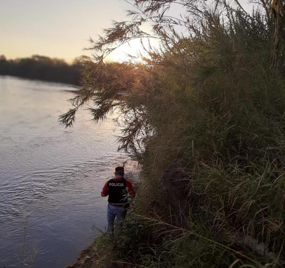 EN PLENO RECORRIDO. Un efectivo recorre las márgenes de un río del sur de la provincia para tratar de dar con el cuerpo del trabajador rural.