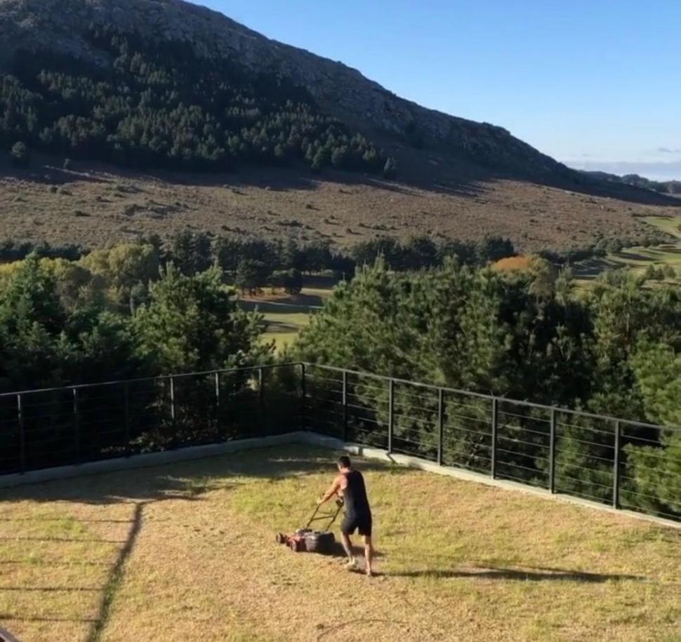  EN SUS QUEHACERES. El “Chavo” cortando el pasto, con la sierra de fondo.