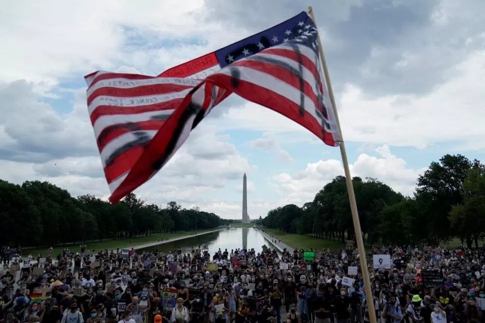 CONTRASTE. El artista Dustin Klein proyectó la imagen de George Floyd sobre la estatua del general confederado Robert E. Lee, en Virginia. fotos Reuters