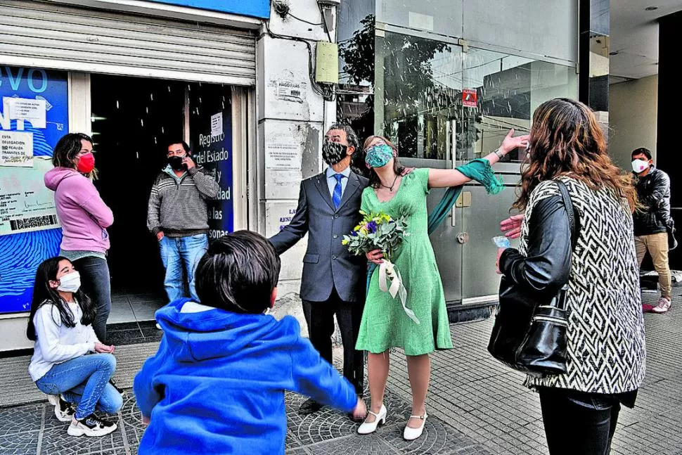 PEQUEÑO FESTEJO. Afuera del edificio algunos familiares esperaban a los recién casados, mientras los niños les tiraban arroz.