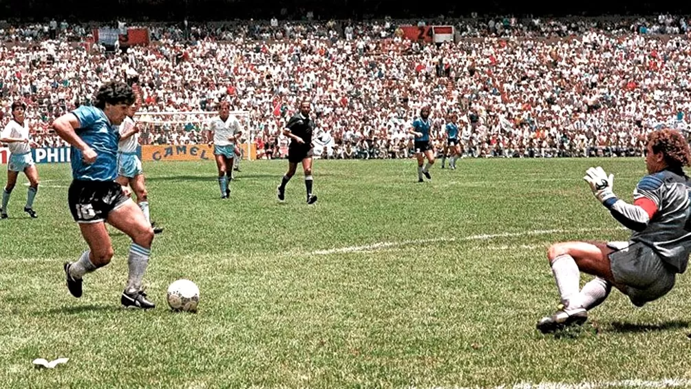 HACIENDO HISTORIA. Maradona amaga, el inglés Shilton cae al piso, vencido, y no podrá evitar el gol. (Télam)