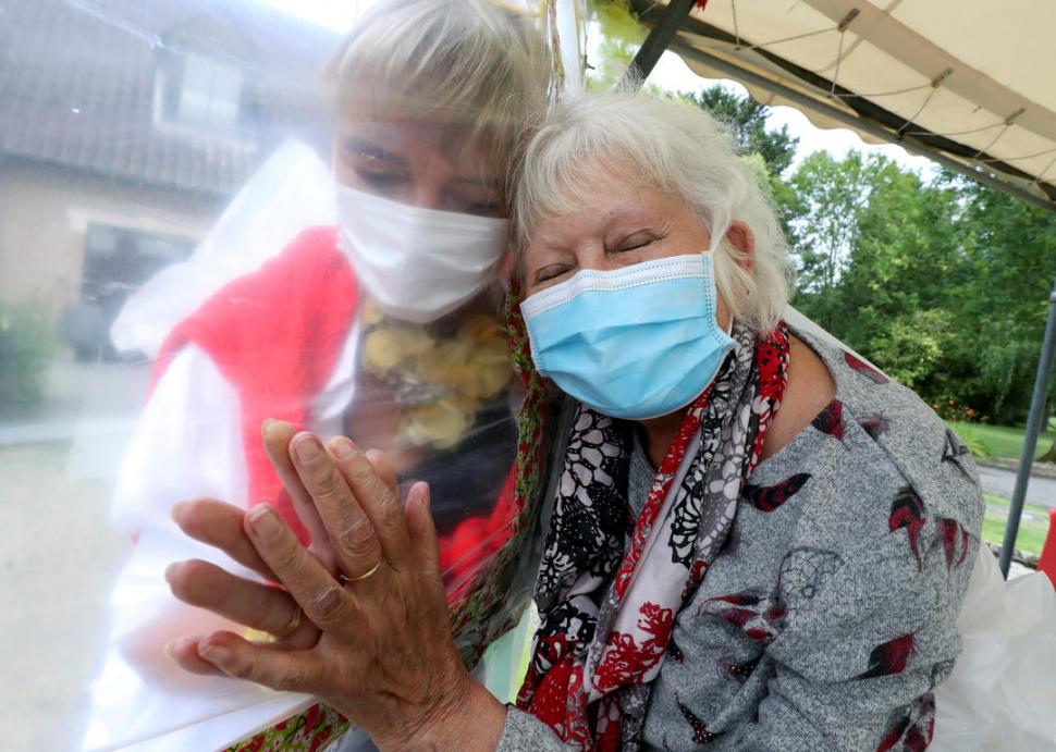 ABRAZOS CUIDADOS. Una residencia para mayores, en Bélgica, ofrece a sus residentes el contacto físico que el coronavirus les niega: a través de una pared plástica.  