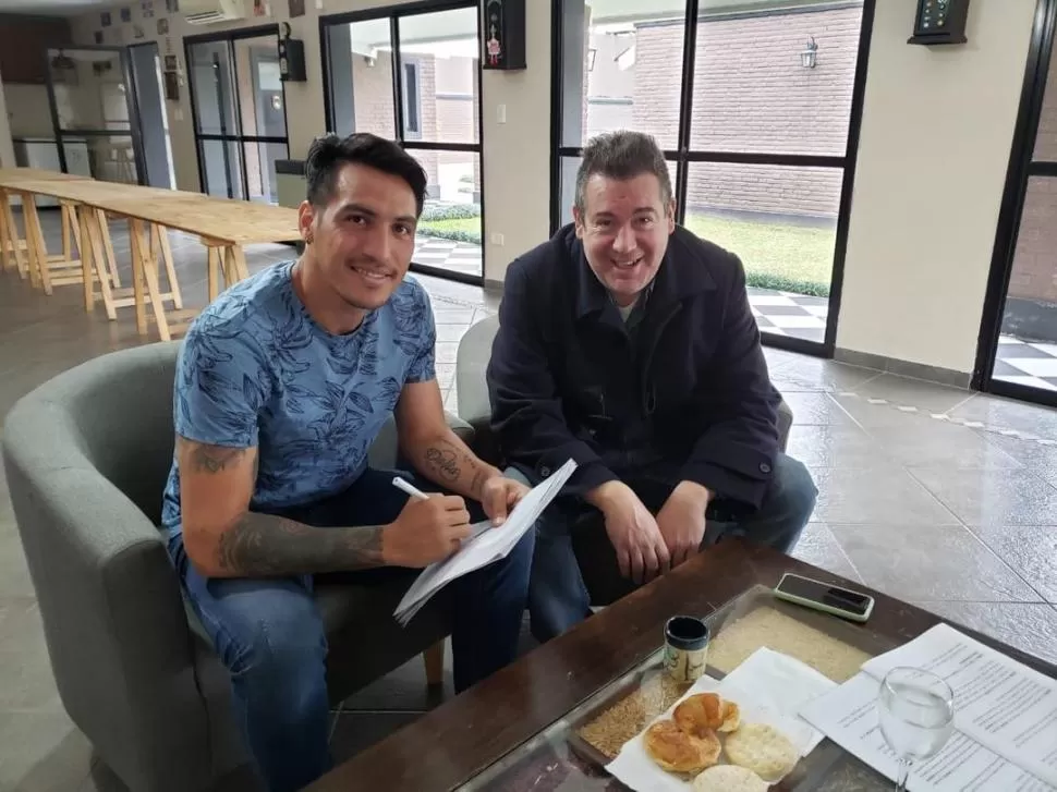 MOMENTO. Monzón posa mientras estampa su firma para un nuevo contrato con Atlético, con Miguel Abbondándolo al lado. la gaceta / foto de DIEGO ARAOZ