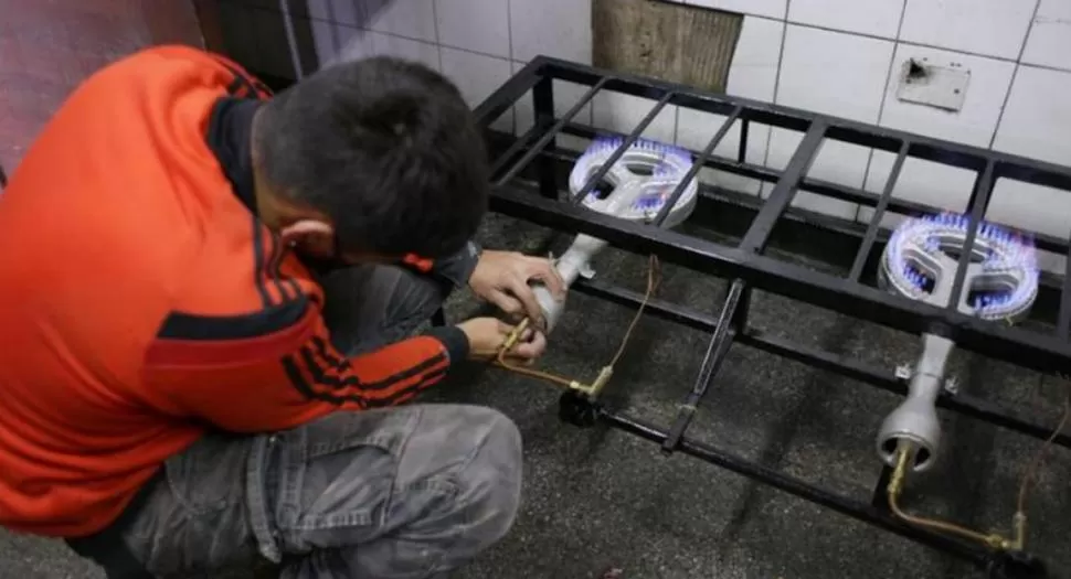 PUESTA A PUNTO. Un operario ultima los detalles para la instalación de gas natural en los anafes de la cocina del comedor escolar Costanera Norte. COMUNICACIÓN PÚBLICA