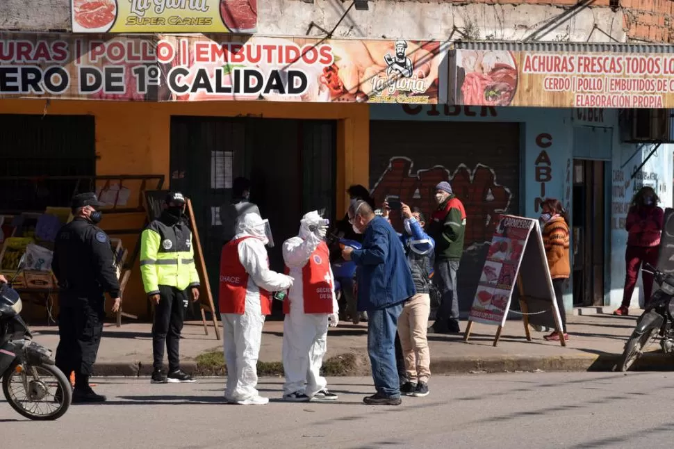 OPERATIVO. Agentes sanitarios y municipales realizaron un relevamiento en Lastenia. Detrás de ellos, los vecinos hacen filas para adquirir productos. la gaceta /  fotos de Inés Quinteros Orio 