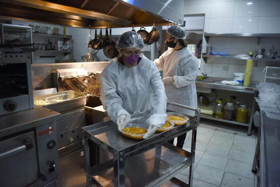 EN LA COCINA. Dos de los tres gerentes que motorizan el guiso solidario (el otro distribuye) preparan las raciones que se distribuyen entre ancianos, familias indigentes y chicos que, habitualmente, piden en los semáforos. la gaceta / fotos de Analía Jaramillo