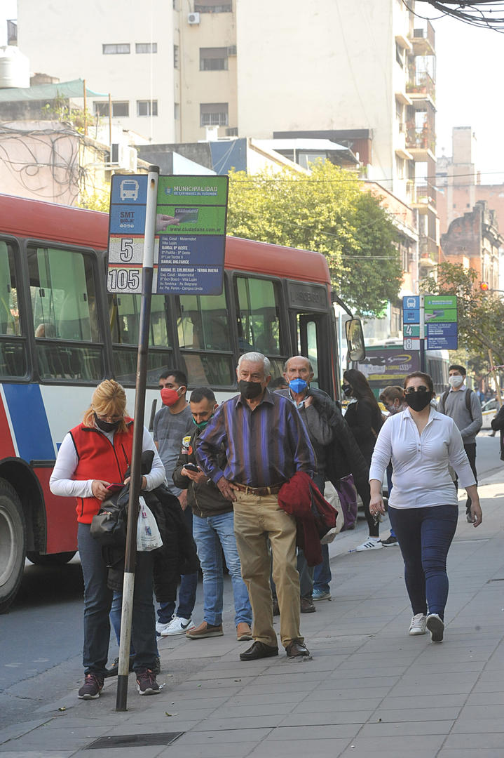 CON TAPABOCA. En esta parada ubicada en el centro de la ciudad, los que aguardan el ómnibus mantienen cierta distancia. El COE fijó multas de entre $ 2.000 y $ 30.000 para los que no lleven barbijos.