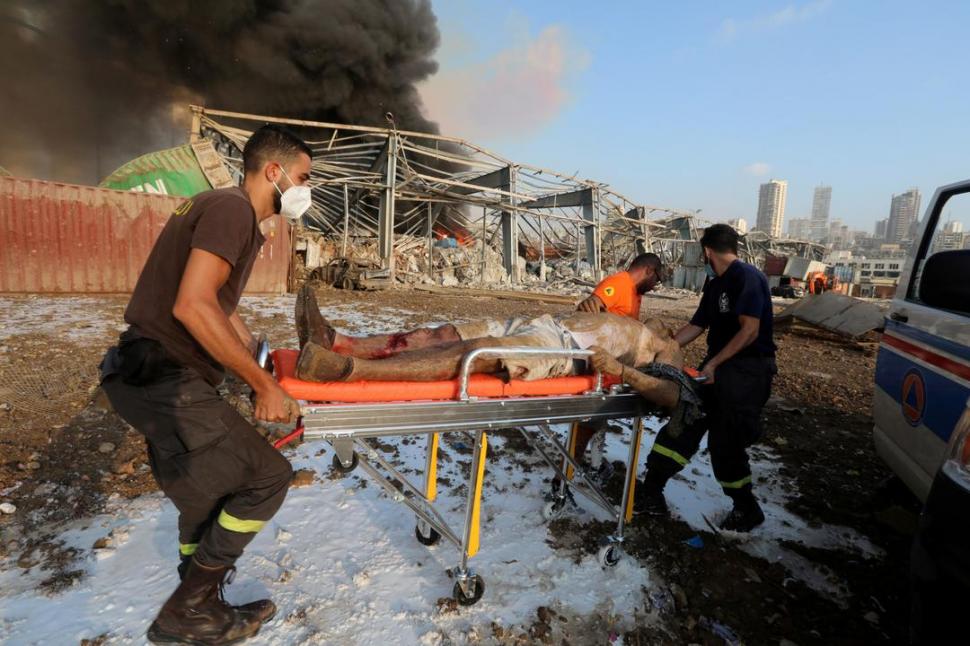 HERIDOS. Rescatistas sacan de entre los escombros a un hombre que sufrió lesiones como consecuencia de las detonaciones en Beirut. 