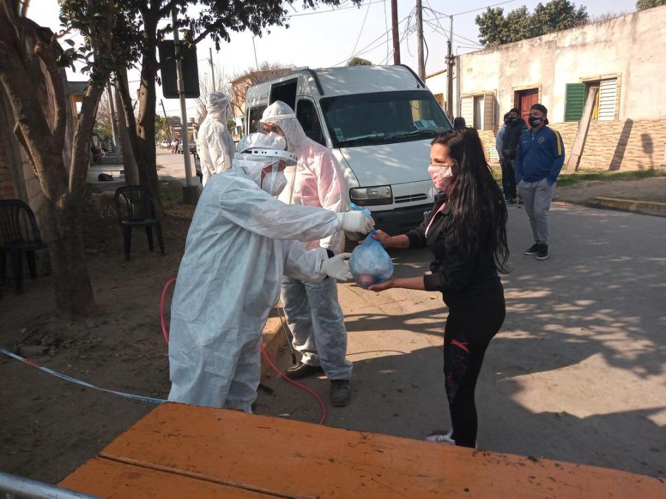 PROVISIONES. Un agente sanitario entrega suministros a una joven. 