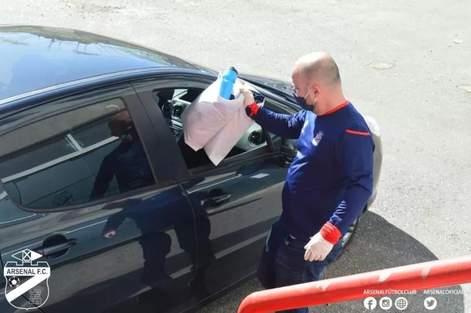  CONTROLES. Un empleado de Arsenal le entrega los elementos de trabajo a un integrante del plantel antes de los testeos. 