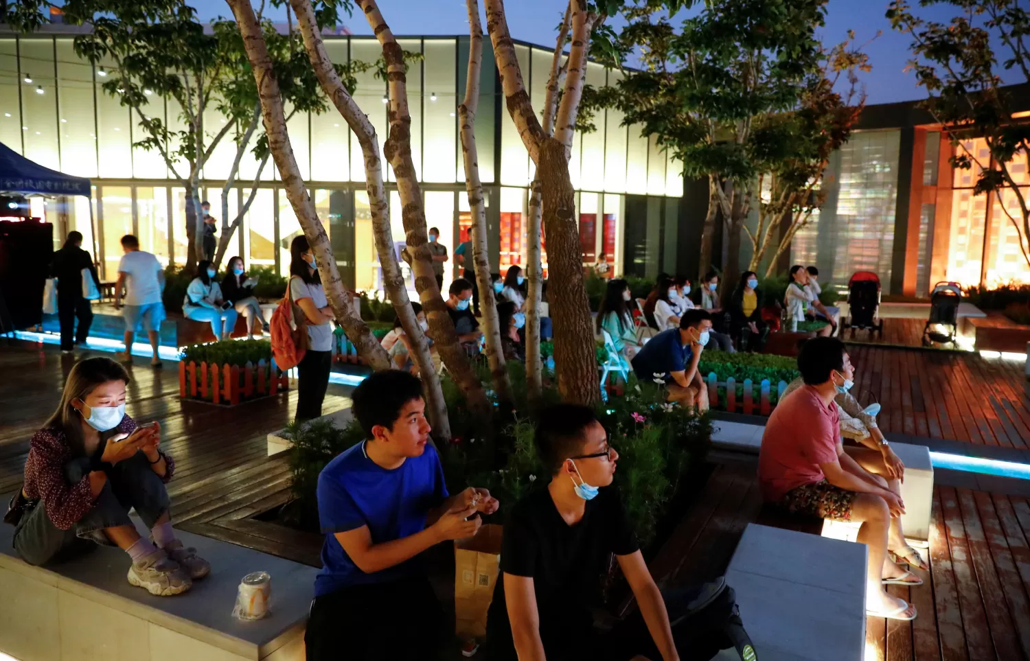 VUELTA AL CINE. Un grupo de personas mira una película en la azotea de un shopping, en la apertura del 10 ° Festival Internacional de Cine de Beijing.