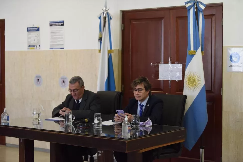 EN EL PASILLO. El juez Pedicone (der.) y el secretario Valladares chequean sus celulares en la audiencia “estéril.” la gaceta / foto de Analía Jaramillo