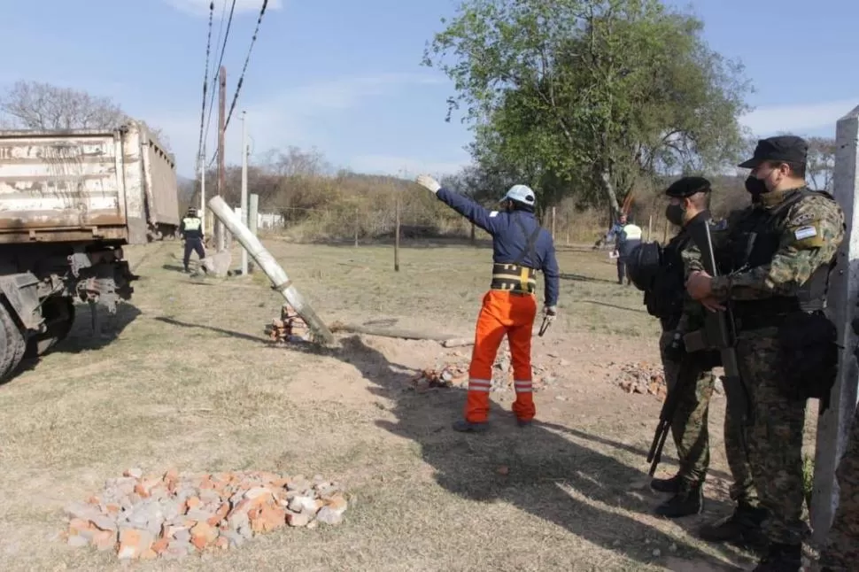 VIGILADOS. Operarios retiran alambrados de un terreno ocupado.  