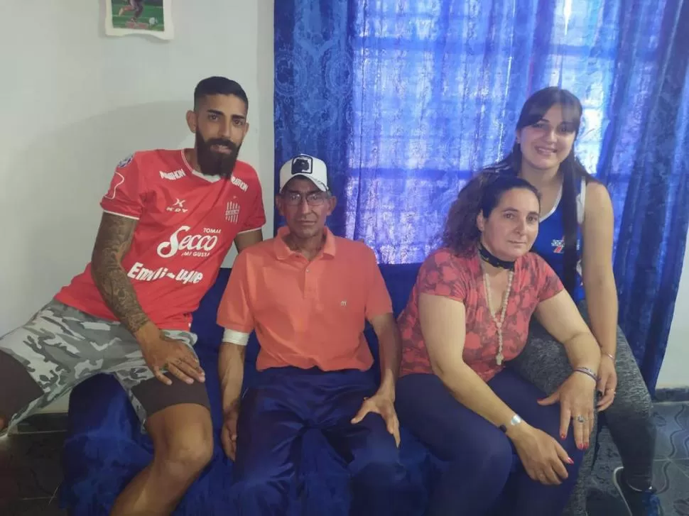 UN DOMINGO EN FAMILIA. Con la camiseta “santa” puesta, Juan posa junto con papá Juan Antonio; mamá Analía; y su hermana, Rocío. “Lo peor ya pasó”, asegura.  