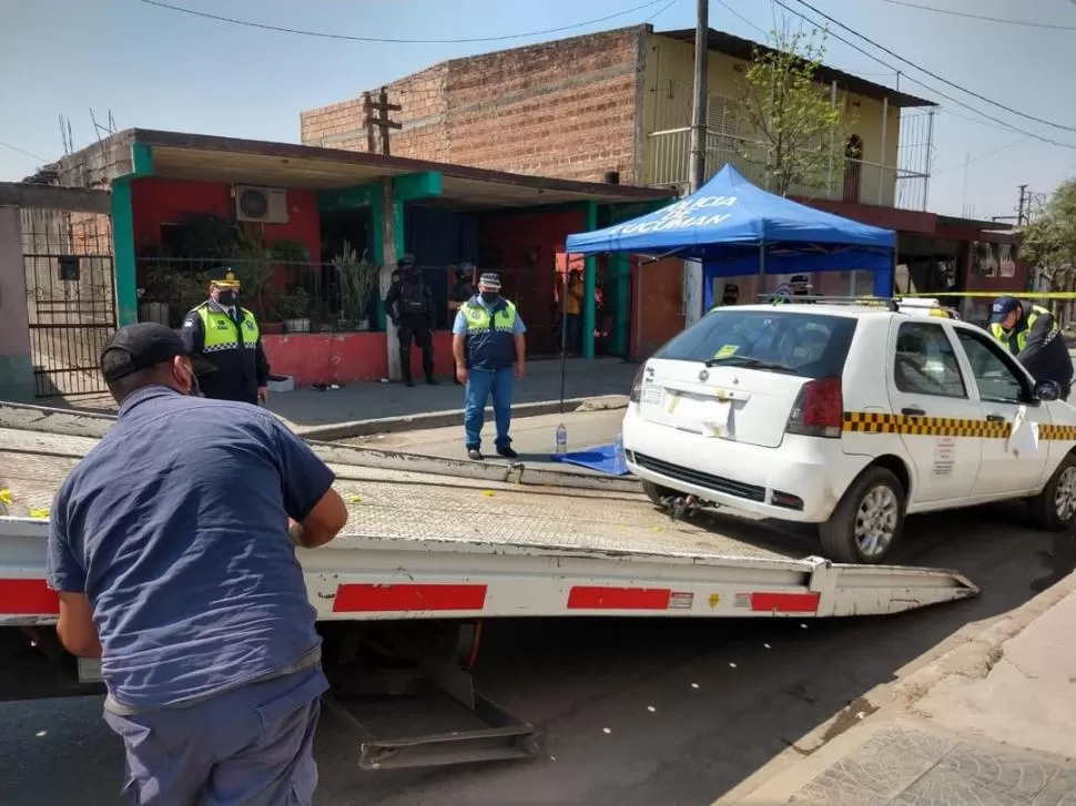 AL CORRALÓN. Policías retiran el taxi que habría sido utilizado en el hecho.