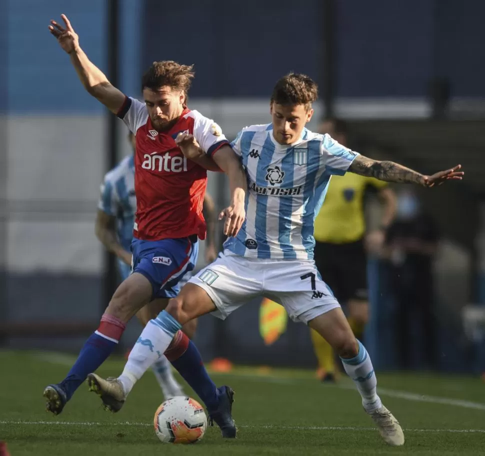 NO PUDO. Fértoli disputa la pelota en un partido en el que Racing no tuvo suerte. télam