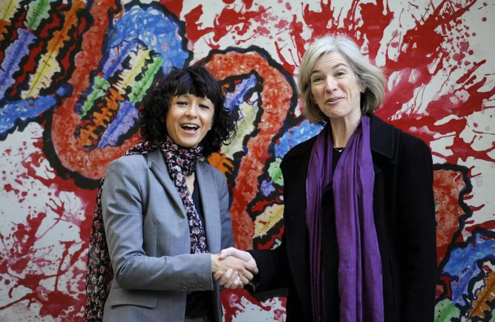 COLEGAS. Las científicas Emmanuelle Charpentier (izquierda) y Jennifer Doudna (derecha) estrechan sus manos. 