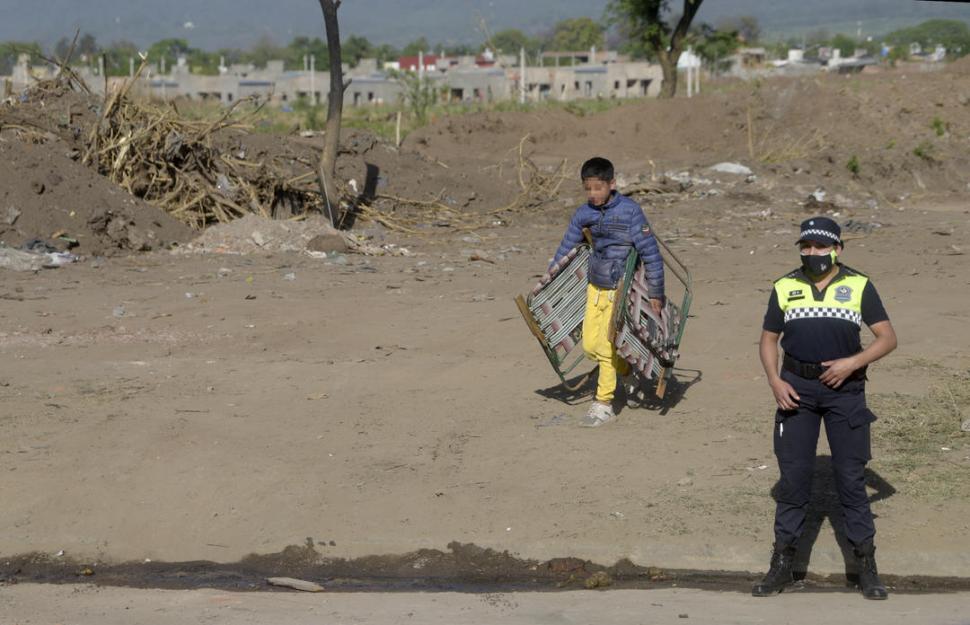 LA OTRA CARA. Un niño carga dos reposeras durante el desalojo efectuado.